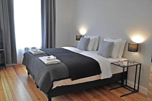 ジェロナ・グラにあるApartament Greyのベッドルーム1室(大型ベッド1台、ランプ2つ、テーブル付)