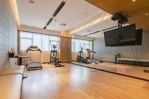 a gym with exercise bikes and a flat screen tv at Echarm Hotel Nanning Chaoyang Square River View in Nanning