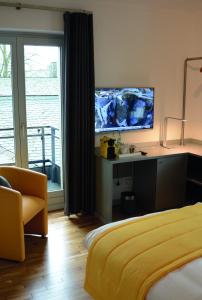 1 dormitorio con 1 cama y escritorio con TV en Amel Mitte en Amblève