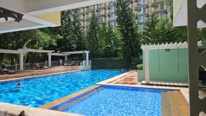 a large swimming pool with a building in the background at Studio Type Condo with balcony Davao City in Davao City