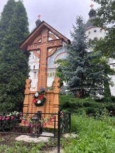 a cross on a fence in front of a church at Casa Isabela in Ocna Sibiului