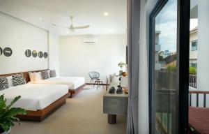 a hotel room with two beds and a balcony at Gold Smith Residence in Siem Reap