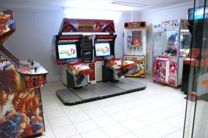 a video game arcade with two arcade machines in a room at Golden Dolphin Grand Hotel via Hmaster in Caldas Novas