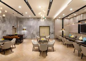 a rendering of a restaurant with tables and chairs at Echarm Hotel Guilin Railway Station the MixC in Guilin