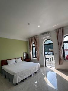 a bedroom with a bed and a large window at Tamcoc Sunseekers Homestay & Hostel in Ninh Binh