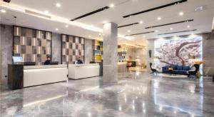 a lobby with desks and chairs in a building at Echarm Hotel Guilin Railway Station the MixC in Guilin