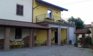 Casa blanca y amarilla con mesa y sillas en Agriturismo Il Vecchio Portico, en Francavilla Bisio