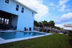 a house with a swimming pool in the yard at Sea'scape - Heated Pool, Beach Gear, Pet Friendly, Beach Views in Pensacola Beach