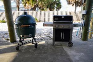 a grill and a trash can next to a stove at Sea'scape - Heated Pool, Beach Gear, Pet Friendly, Beach Views in Pensacola Beach