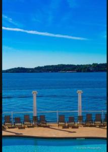 una fila de sillas sentadas junto a un cuerpo de agua en 3BD 3BA Gated Condo LakeFront Lake Ozark, MO Isla Del Sol 4 M from Dam, en Rocky Mount 1 foto más