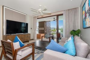 a living room with a couch and a flat screen tv at Luxury Infinity Sky Pool Suite Angsana Laguna Lakeside in Phuket Town