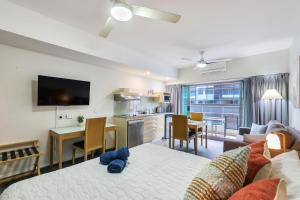 ダーウィンにあるDarwin City Centre Apt 2 Bed, 2 Bathのリビングルーム(ベッド1台付)、キッチンが備わります。