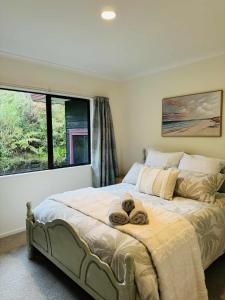 une chambre avec un grand lit avec deux serviettes dessus dans l'établissement Coastal Comfort - Views for the Whole Crew, à Tauranga