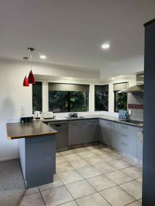 une grande cuisine avec une grande île au milieu dans l'établissement Coastal Comfort - Views for the Whole Crew, à Tauranga