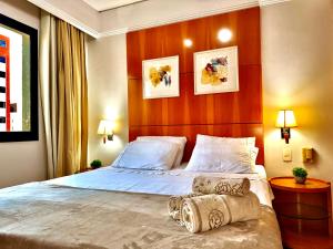 ein Schlafzimmer mit einem großen Bett mit einem hölzernen Kopfteil in der Unterkunft Flat em Hotel de Luxo MercPrivilege - 5 Min do Aeroporto in São Paulo + 30 Fotos