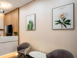 a living room with two chairs and a table at Green Tree Inn Shenyang Middle Street in Shenyang