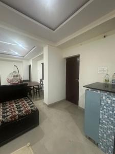 ヴィシャカパトナムにあるSri Dutta Residencyのリビングルーム(ベッド1台付)、キッチン、テーブルが備わります。