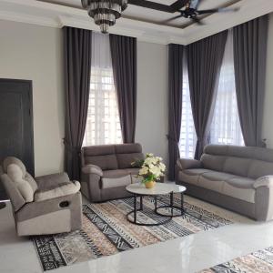 a living room with two couches and a table at HomeStay Rafiza in Jertih