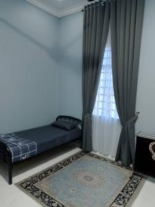 Ένα ή περισσότερα κρεβάτια σε δωμάτιο στο HomeStay Rafiza +2 φωτογραφίες