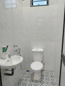 a bathroom with a white toilet and a sink at HomeStay Rafiza in Jertih