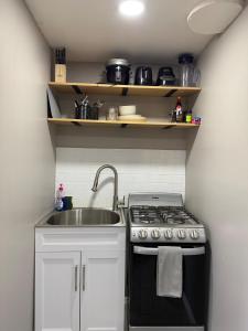 une petite cuisine avec un évier et une cuisinière dans l'établissement Cozy Casita Near AIRPT, DT, UTEP, Ft Bliss, à El Paso