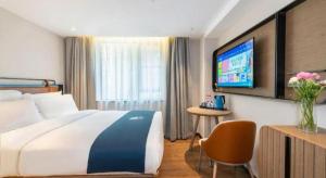 a hotel room with a large bed and a television at Echarm Hotel Guangzhou Tiyu West Raod Metro Station in Guangzhou