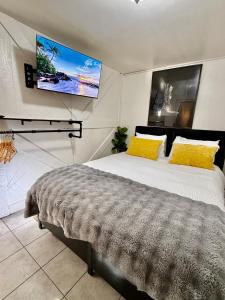 - une chambre avec un lit et une télévision murale dans l'établissement Cozy Casita Near AIRPT, DT, UTEP, Ft Bliss, à El Paso