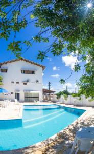 a swimming pool in front of a building at Vila do Galo in Porto De Galinhas