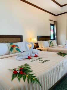 ein Hotelzimmer mit zwei Betten mit Blumen darauf in der Unterkunft Coral Resort in Ko Chang + 160 Fotos