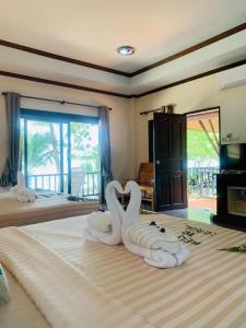 zwei Schwäne auf einem Bett in der Unterkunft Coral Resort in Ko Chang