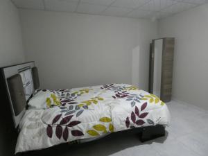 a bedroom with a bed with a floral comforter at Huayo Wasi II in Huaraz