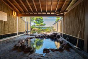 - une piscine avec des rochers au milieu d'un bâtiment dans l'établissement 洗心和方 Senshin Waho, à Awaji