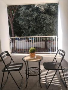 una mesa y sillas en un balcón con una maceta en Careggi apartment, en Florencia