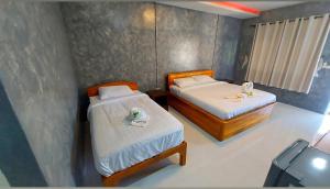 two beds in a small room with two beds sidx sidx sidx at J House Has Love in Sukhothai