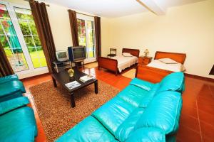 a living room with a blue couch and a bed at Casa da Portada in São Vicente