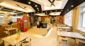 a restaurant with white tables and chairs and windows at Jinjiang Inn Style Shenyang The Palace Huaiyuan Gate in Shenyang