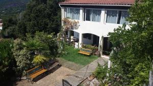 an aerial view of a house with benches in the yard at Le Gîte Radica in Eccica-Suarella