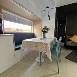 a dining room table with a vase of flowers on it at Mobilheim am Murner See - privater Badezuber & Grill in Wackersdorf +7 photos