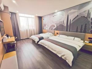 a hotel room with two beds and a painting on the wall at Thank Inn Plus Hotel Jiangyin University in Wuxi