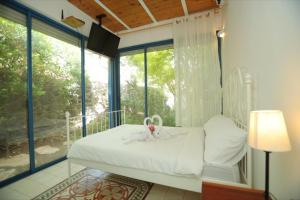 a bedroom with a bed and a large window at טורקיז - בריכה פרטית in Had Nes +29 photos