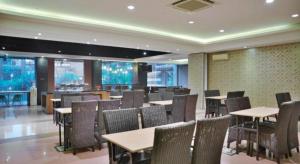 a restaurant with tables and chairs and a bar at Sleepzzz Hotel Senayan in Jakarta
