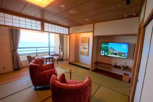 un salon avec des chaises et une télévision à écran plat dans l'établissement 洗心和方 Senshin Waho, à Awaji