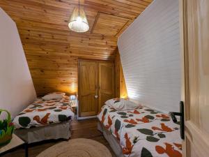 two beds in a room with wooden walls at Gîte rénové pour 4 pers. avec accueil équin, Saint-Front - FR-1-582-538 in Moudeyres