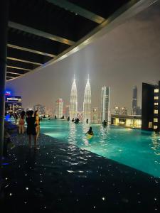 a group of people in a swimming pool in a city at Eaton Residences KLCC - Luxury Apartment in Kuala Lumpur