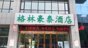 a sign for a store in front of a building at GreenTree Inn Urumqi Airport Tianyi International City in Ürümqi