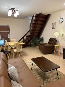 una sala de estar con un sofá y una mesa en Golden Heaven, en Suratthani
