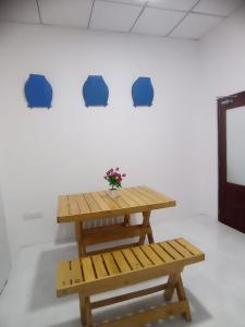 una mesa de madera y un banco frente a una pared en Casa Tranquila, en Talalla South