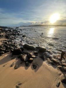 un grupo de rocas en una playa con el océano en Casa Tranquila, en Talalla South