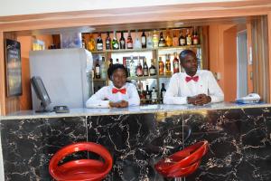 a man and a woman standing at a bar at Charriot Hotels in Abuja