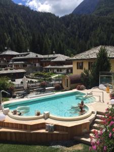 uma piscina num resort com montanhas ao fundo em Hotel Relais Des Glaciers - Adults Only em Champoluc